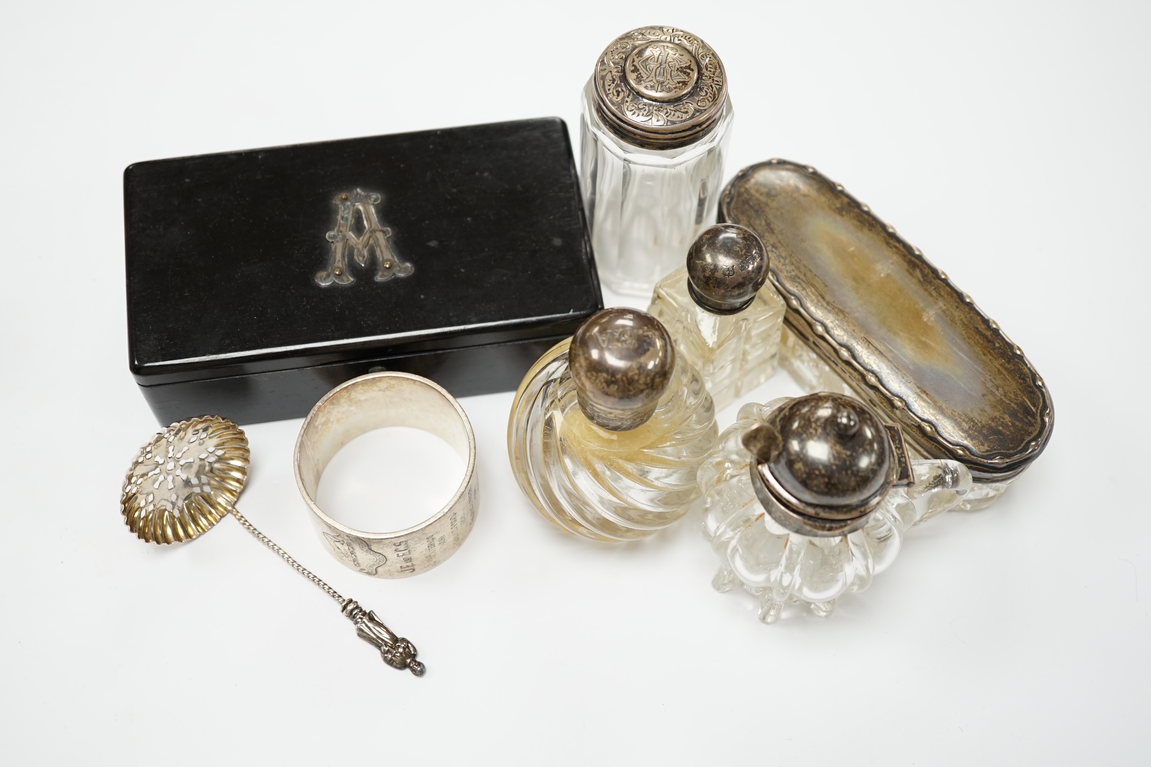 Four assorted silver mounted glass toilet jars, an Edwardian silver mounted glass mustard jar with spoon, a silver napkin ring, sifter spoon and ebony box. Condition - poor to fair